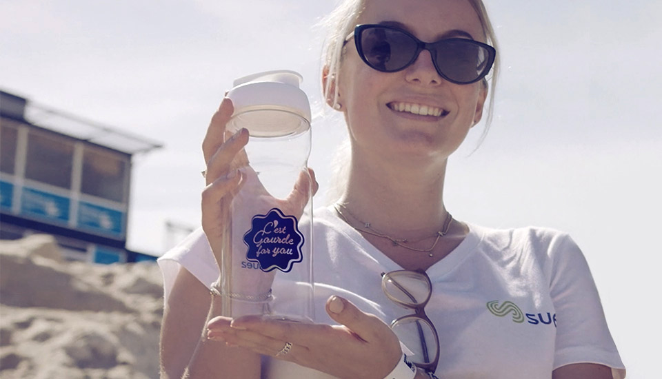 Distribution de gourdes en verre sur la plage pour sensibiliser aux problèmes des déchets plastiques